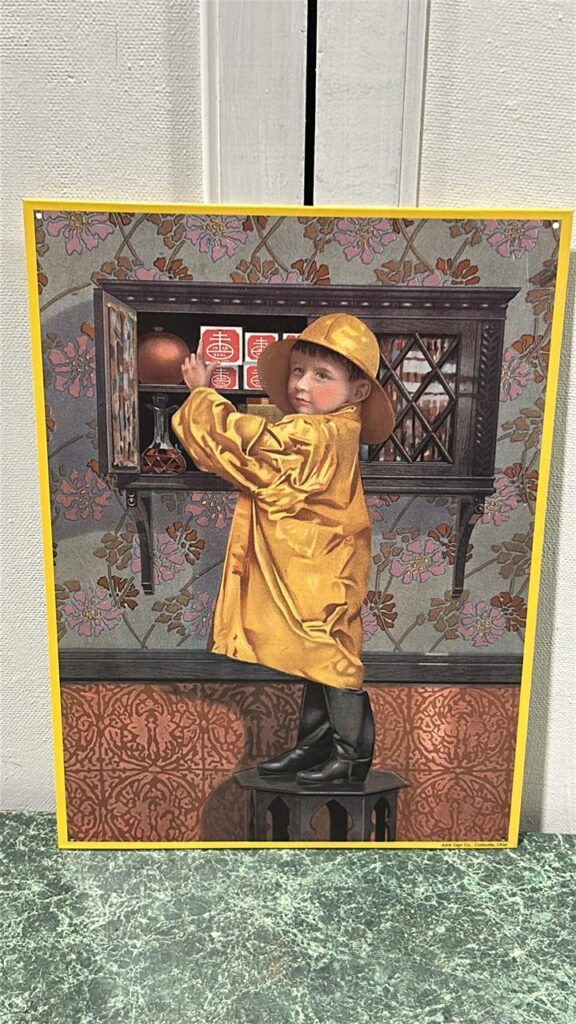 Metal sign that shows a young child standing in front of a open window cupboard that has square white boxes with red picture on it,