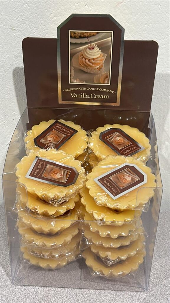 dark brown display box with 4 columns of 6 scalloped edged beige coloured wax melts