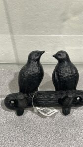 Picture of a cast iron 2 hook wall hanger that looks like 2 small birds perched facing each other on a metal branch
