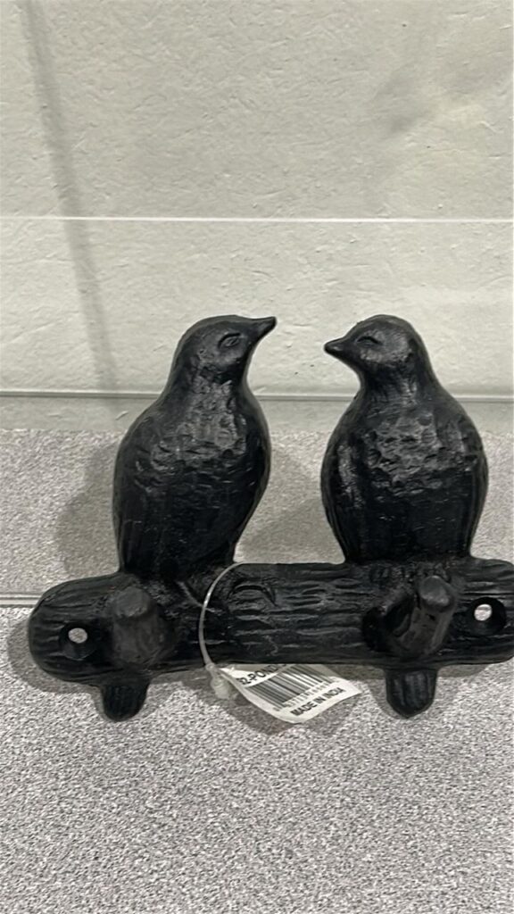 Picture of a cast iron 2 hook wall hanger that looks like 2 small birds perched facing each other on a metal branch